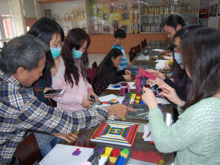 教師圍桌操作生活數學教具,與講師近距離互動