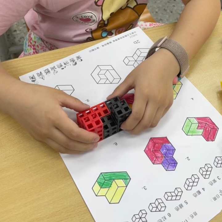孩子用立體連接方塊照步驟拼出指定結構